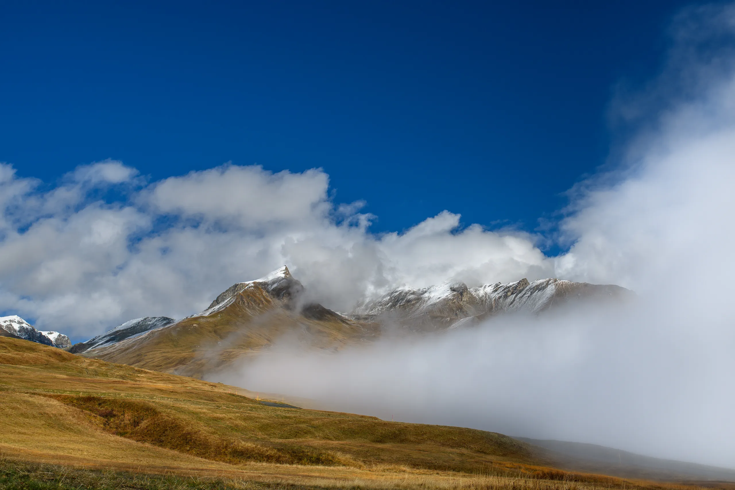 Snow-covered peaks emerging through the clouds.