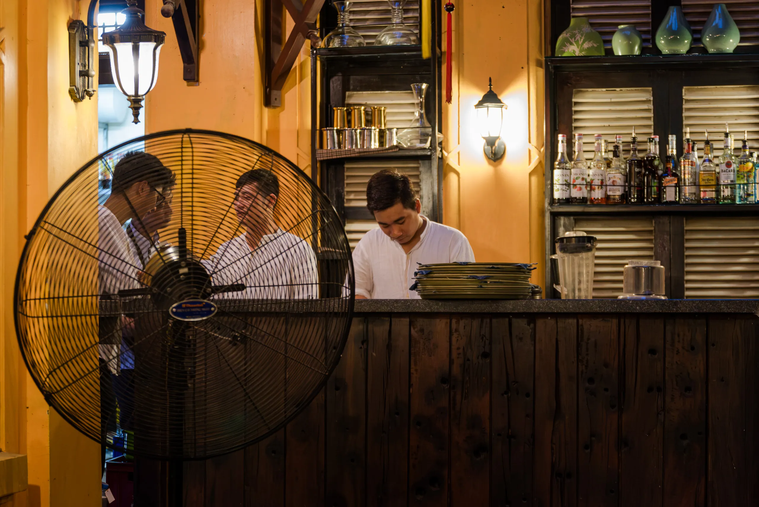 Everyday life scene in Hanoi with a large fan