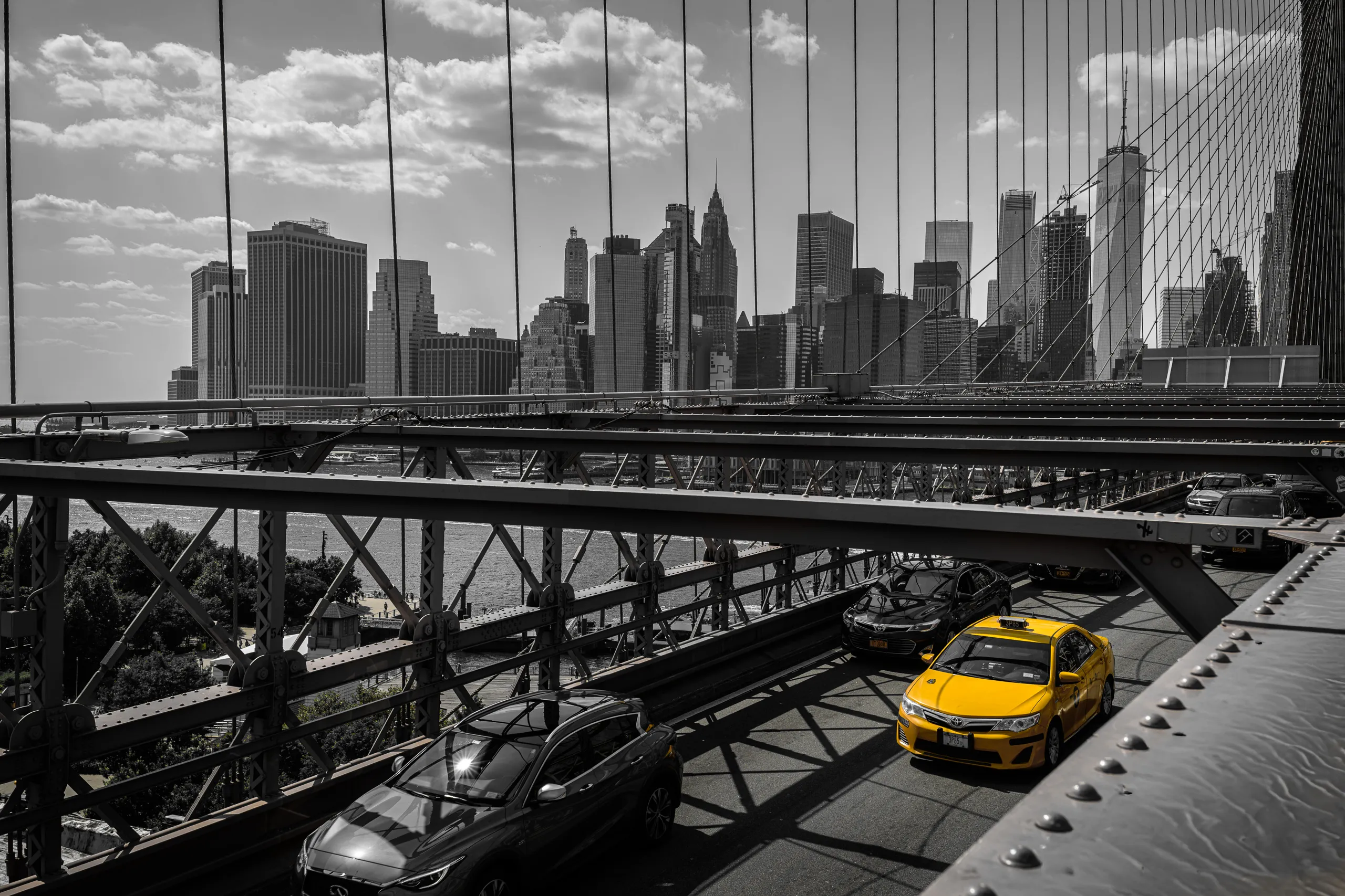 Yellow taxi in front of the Brooklyn Bridge in New York