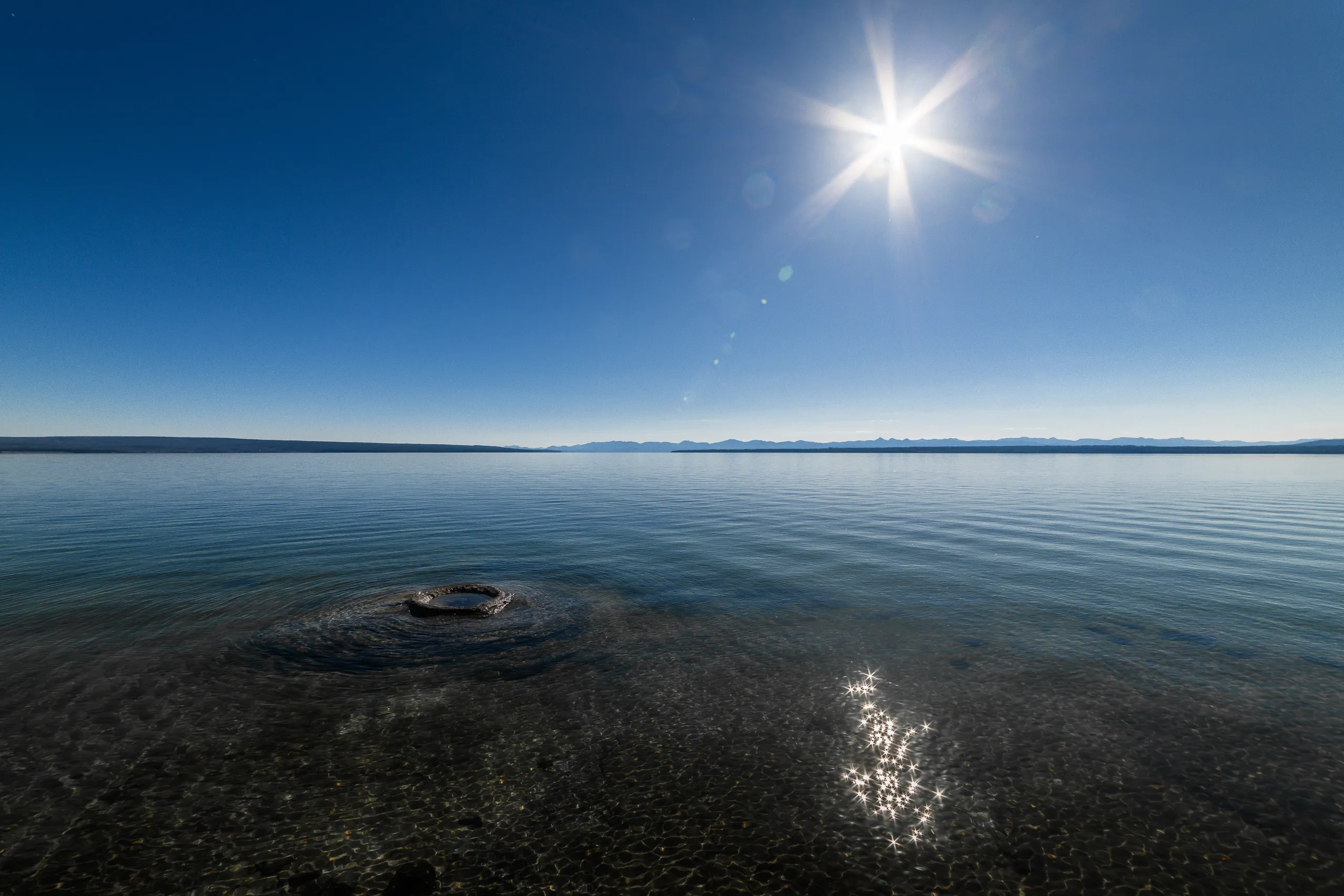 Sun above a vast landscape viewed from high ground
